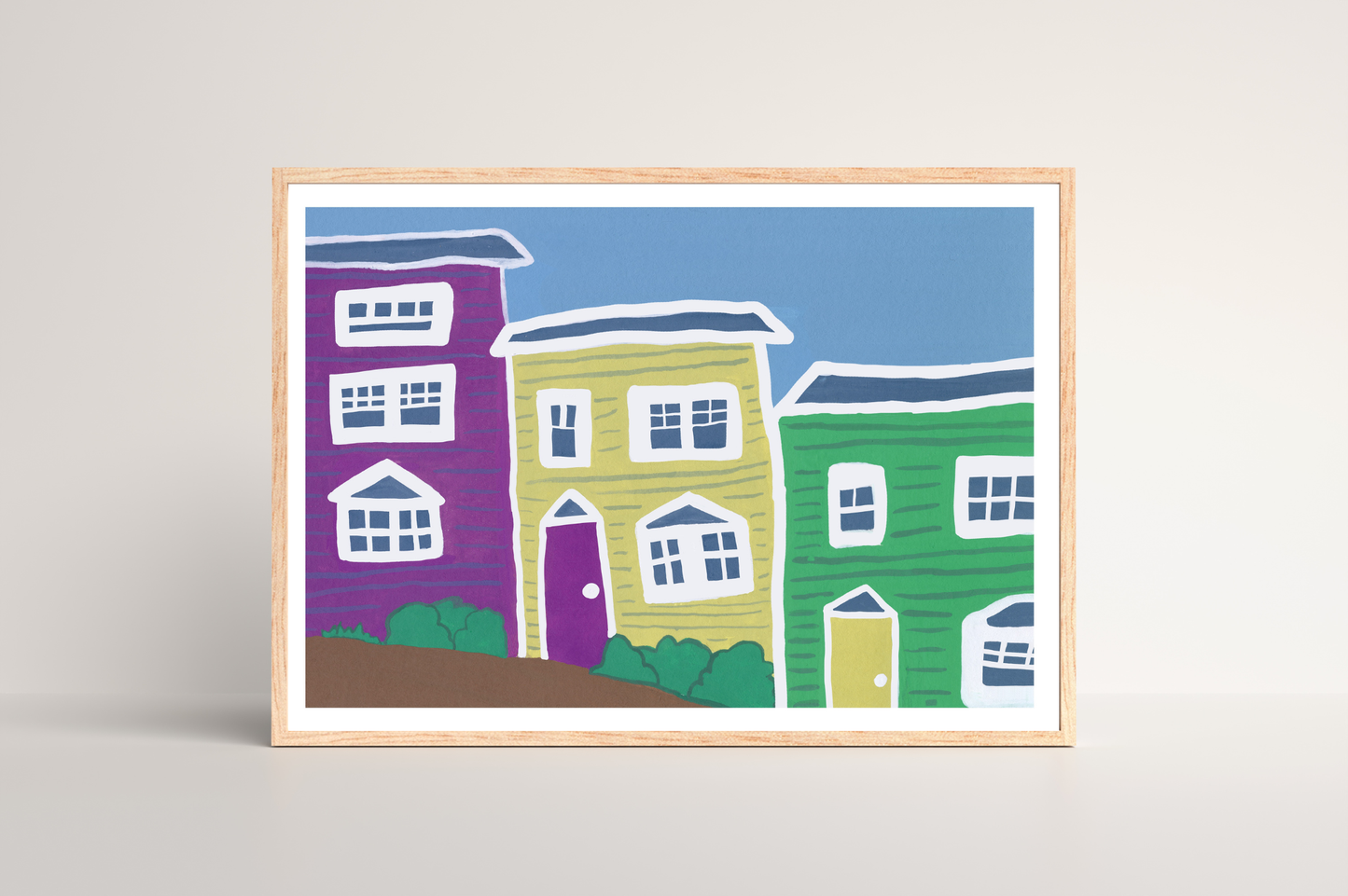 Framed artwork of colorful pastel houses on a light blue background