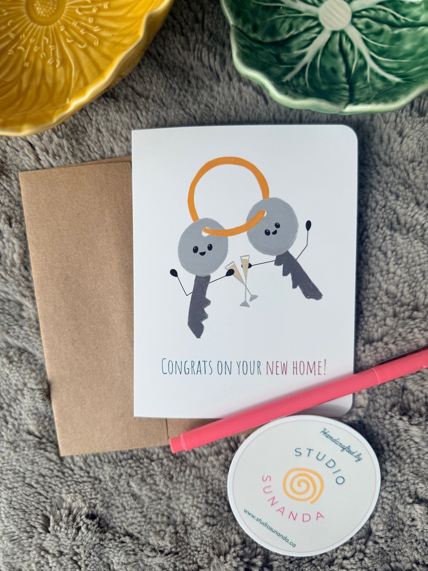 Congratulations greeting card for a new home, with two smiling house keys clinking champagne flutes in the illustration.